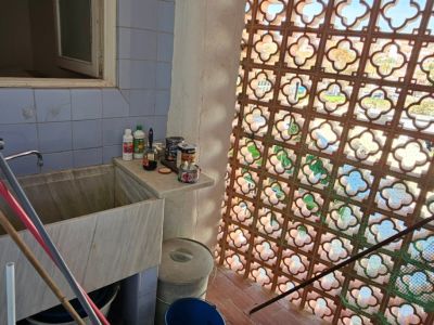 Zona de servicio con un gran lavadero de mármol, azulejos azules y celosía de terracota que filtra la luz natural. Espacio con potencial de reforma.