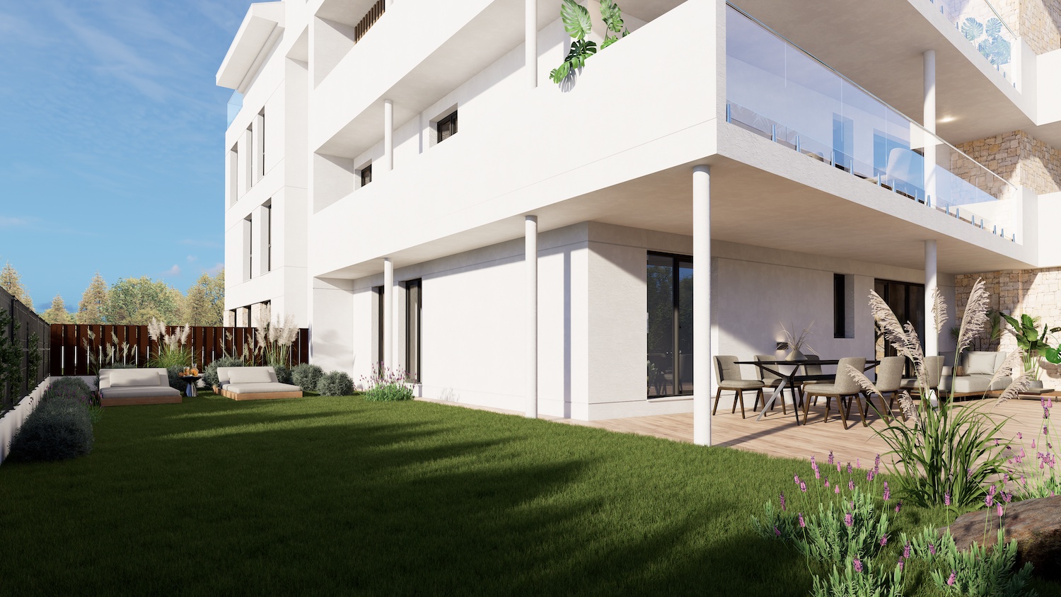 Apartamento en planta baja con jardín privado de césped cuidado y dos tumbonas. La terraza cubierta dispone de zona de comedor exterior y un espacio lounge sobre tarima de madera.