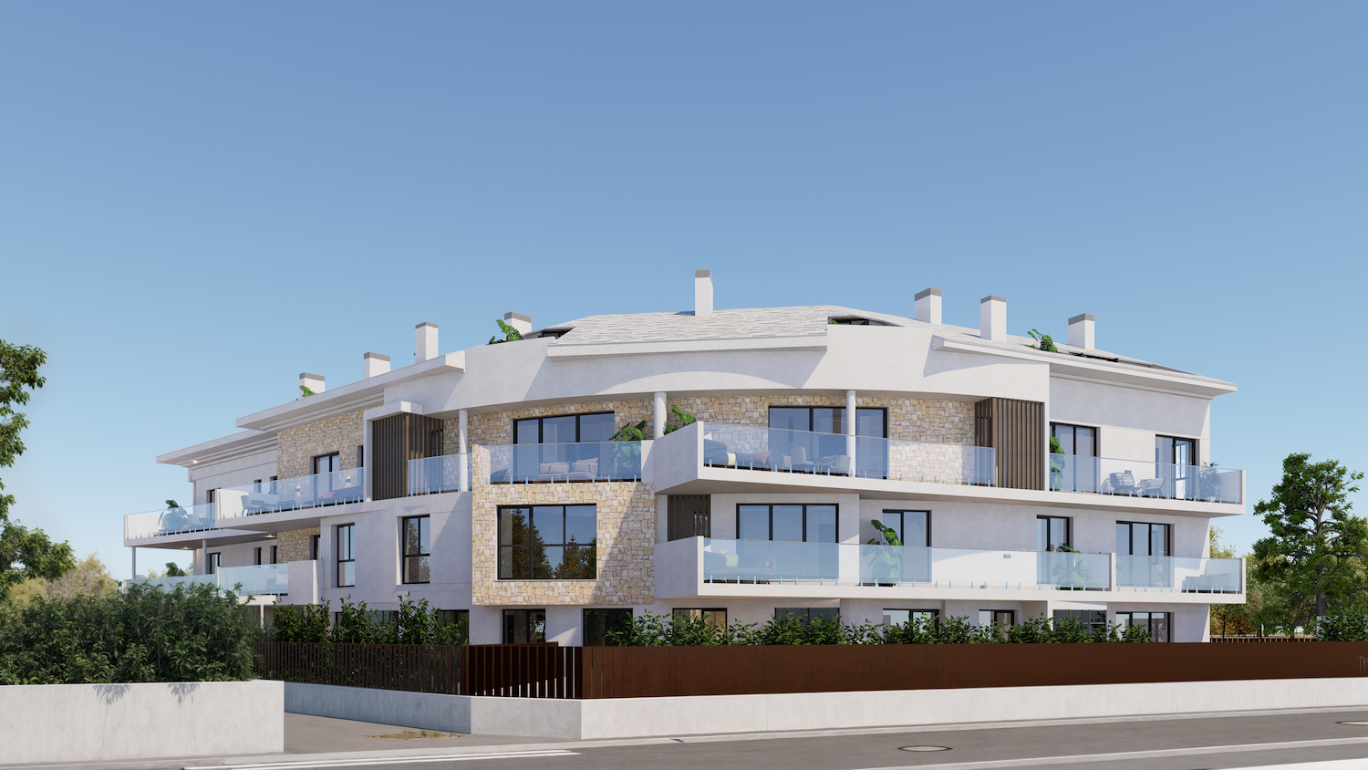 Edificio de apartamentos moderno con fachada de estuco blanco, detalles de piedra natural y balcones con barandillas de cristal y mobiliario exterior. Presenta una sección curva distintiva con vegetación integrada.