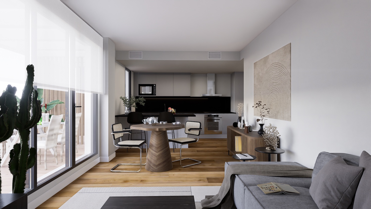 Espacio diáfano que integra una cocina moderna en tonos grises con salpicadero negro, una zona de comedor con mesa de base de espiga de madera y grandes ventanales a una terraza exterior.