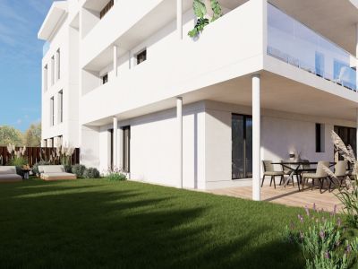 Apartamento en planta baja con jardín privado de césped cuidado y dos tumbonas. La terraza cubierta dispone de zona de comedor exterior y un espacio lounge sobre tarima de madera.