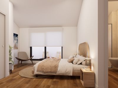 Dormitorio principal con suelo de madera cálida, cabecero de ratán y acceso a una terraza privada. El baño en-suite con lavabo flotante es parcialmente visible.