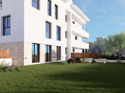 Edificio de apartamentos moderno con base de piedra y amplios ventanales que dan a un extenso césped. Jardín mediterráneo con lavanda y tumbonas para una zona exterior tranquila.