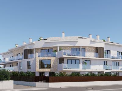 Edificio de apartamentos moderno con fachada de estuco blanco, detalles de piedra natural y balcones con barandillas de cristal y mobiliario exterior. Presenta una sección curva distintiva con vegetación integrada.