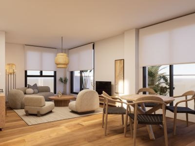 Luminoso salón-comedor de planta abierta con suelos de madera cálida y grandes ventanales. Destaca una mesa redonda de madera con sillas de mimbre y asientos neutros bajo una lámpara de fibras naturales.