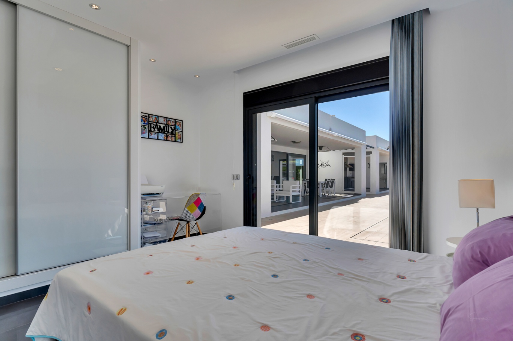 Dormitorio luminoso con acceso directo a la terraza, equipado con armario empotrado de puertas correderas y un rincón de estudio funcional.