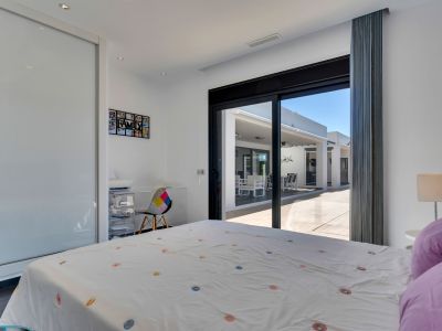Dormitorio luminoso con acceso directo a la terraza, equipado con armario empotrado de puertas correderas y un rincón de estudio funcional.