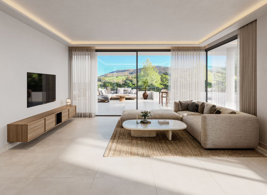 Amplio salón con sofá esquinero neutro, mesa de centro ovalada y mueble flotante de madera. Grandes puertas correderas de cristal conectan con una espaciosa terraza y vistas panorámicas a las colinas verdes.