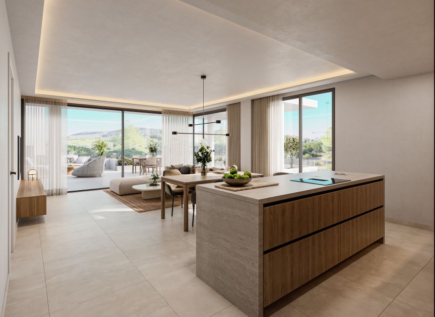 Espacio de vida diáfano moderno con isla de cocina de piedra y madera, comedor contiguo y salón luminoso. Grandes puertas correderas de cristal conectan con una terraza privada y vistas al paisaje verde.