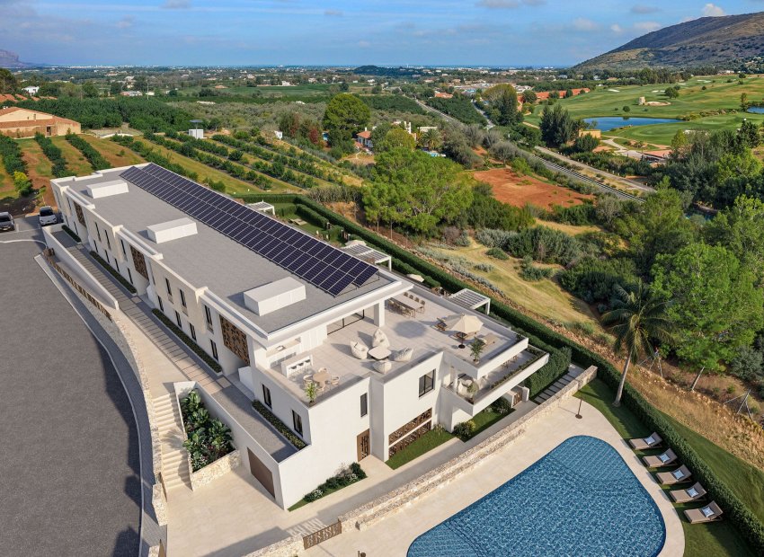Vista aérea de una residencia de lujo moderna con paneles solares en el tejado, múltiples terrazas exteriores con zonas de estar y comedor, y una gran piscina, enmarcada por un campo de golf y huertos.