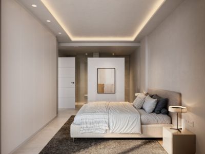 Dormitorio principal moderno con paleta neutra, armarios empotrados de suelo a techo y techo suspendido con iluminación LED ambiental. Una pared parcial divide el área de descanso del baño privado.
