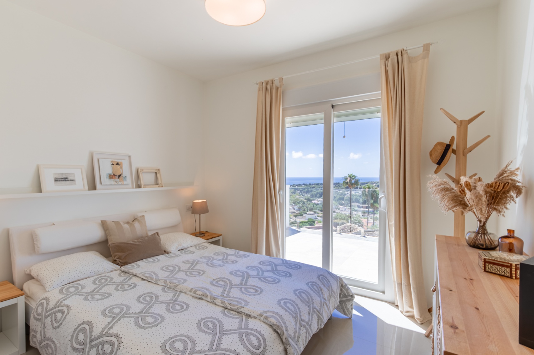 Dormitorio luminoso en planta alta con acceso a terraza, ofreciendo vistas panorámicas al mar Mediterráneo. Incluye mobiliario de madera clara y suelos de azulejo. Dormitorio luminoso en planta alta con acceso a terraza, ofreciendo vistas panorámicas al mar Mediterráneo. Incluye mobiliario de madera clara y suelos de azulejo.