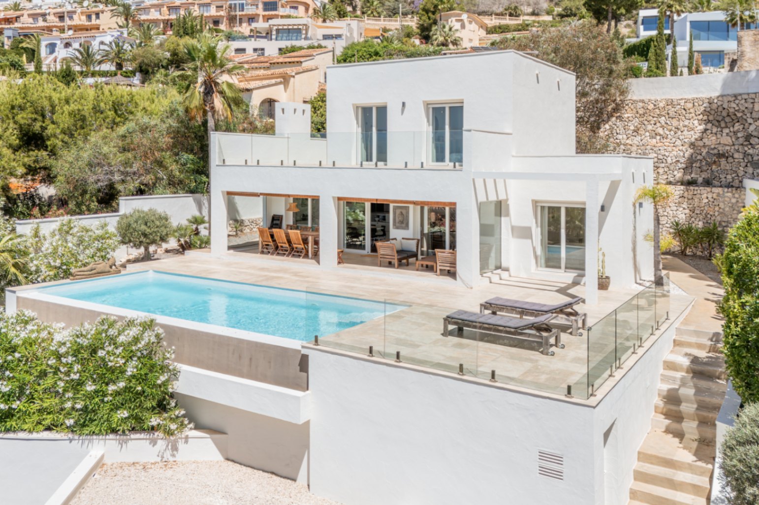 Villa moderna de dos plantas con piscina de borde infinito y amplias terrazas. Incluye zona de comedor exterior cubierta y solárium con tumbonas. Villa moderna de dos plantas con piscina de borde infinito y amplias terrazas. Incluye zona de comedor exterior cubierta y solárium con tumbonas.