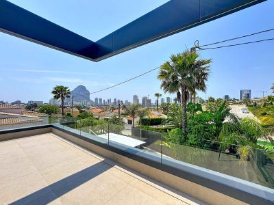 Terraza superior con suelo de gres claro y barandilla de cristal, ofreciendo vistas panorámicas a Calpe, el Peñón de Ifach y la ciudad.