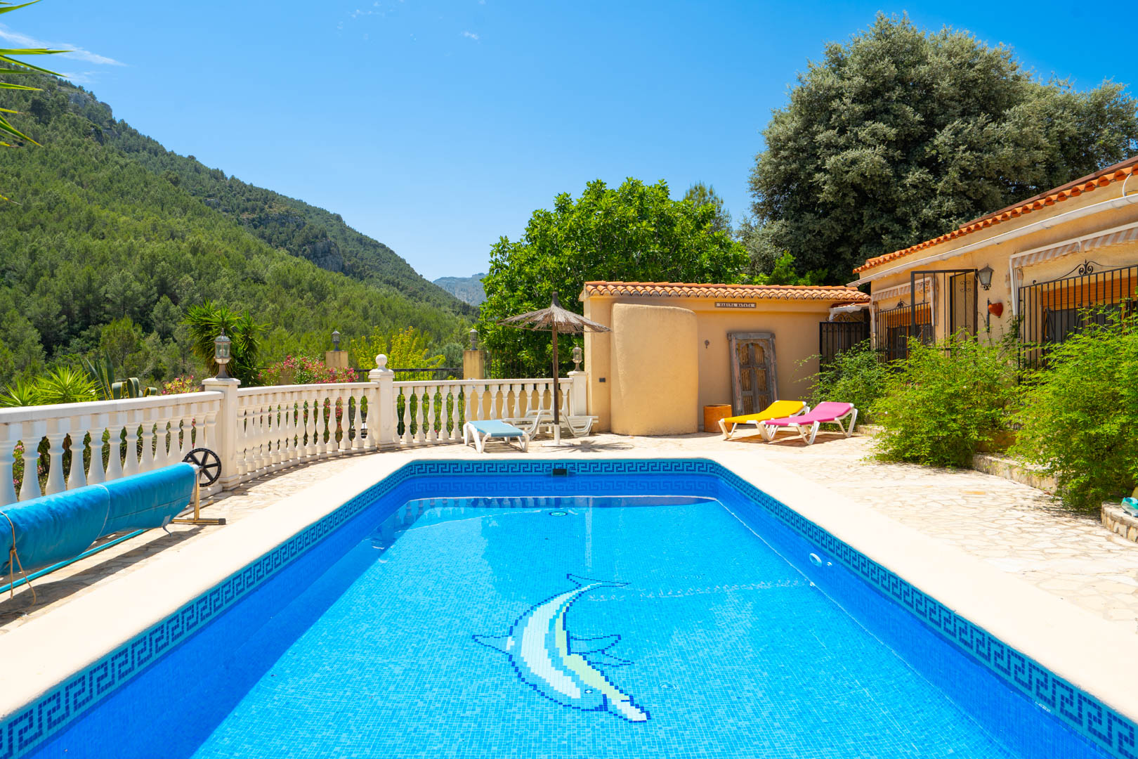 La piscina de azulejos azules presenta un encantador mosaico de delfín y un borde con patrón griego. La terraza circundante ofrece tumbonas y vistas panorámicas a las montañas. La piscina de azulejos azules presenta un encantador mosaico de delfín y un borde con patrón griego. La terraza circundante ofrece tumbonas y vistas panorámicas a las montañas.