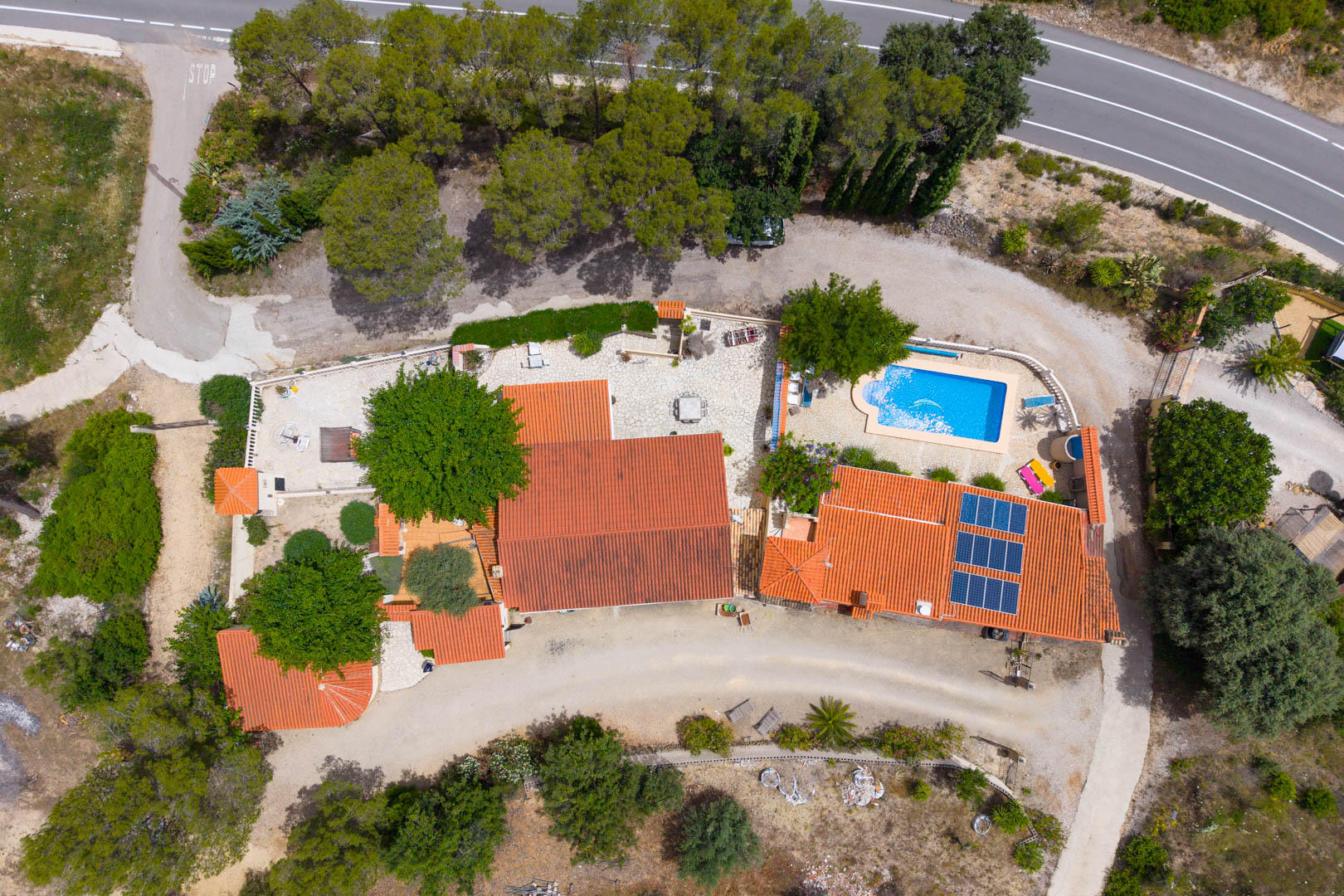 Vista aérea de la finca con dos viviendas, piscina rectangular, paneles solares en uno de los tejados de teja y amplias zonas exteriores. Vista aérea de la finca con dos viviendas, piscina rectangular, paneles solares en uno de los tejados de teja y amplias zonas exteriores.
