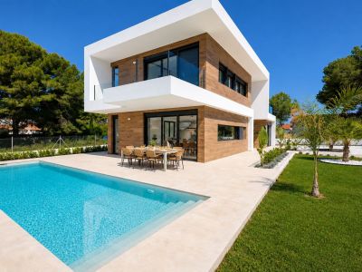 Exterior de villa moderna con piscina privada rectangular y amplia terraza de gres. Un comedor exterior junto a grandes puertas de vidrio, realzado por revestimiento de madera y jardines cuidados.