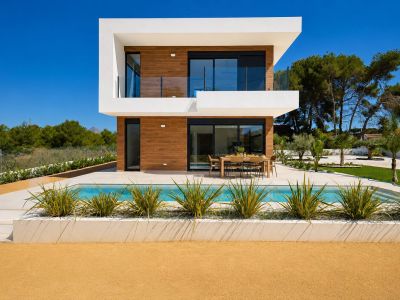 Exterior de villa moderna con piscina privada y comedor al aire libre, fachada de dos plantas con revestimiento de madera y grandes puertas de cristal.