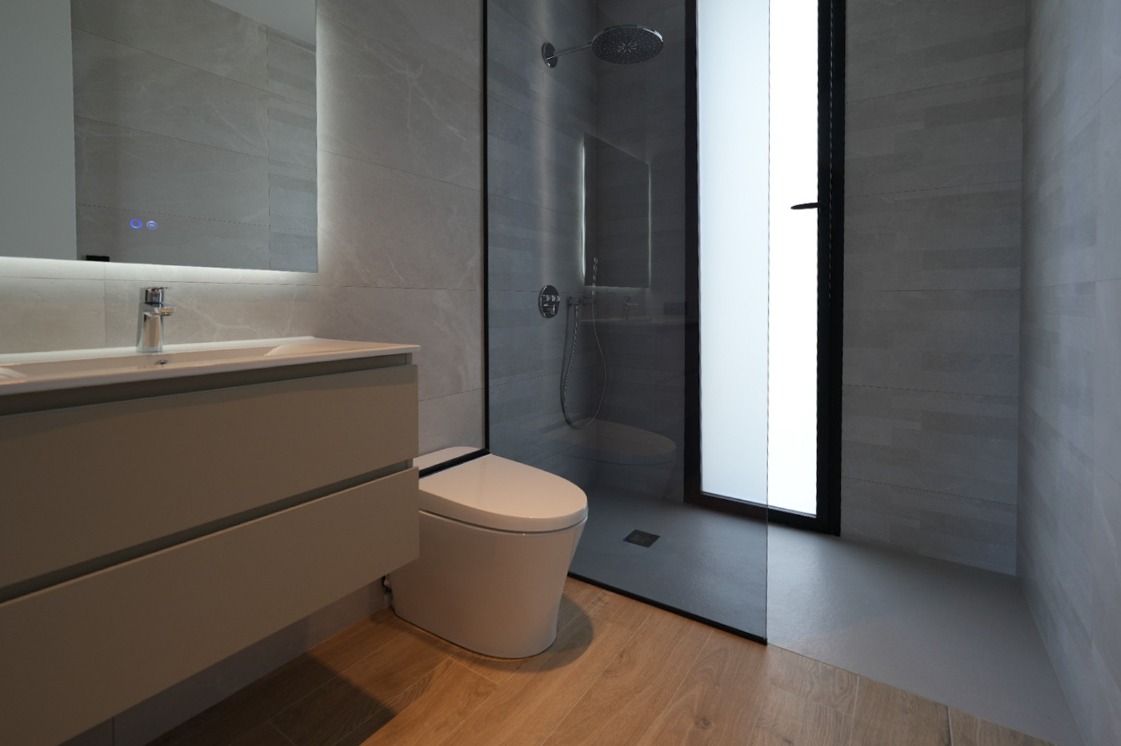 Baño moderno con lavabo flotante, espejo iluminado, inodoro suspendido y ducha a ras de suelo con rociador tipo lluvia, revestido con azulejos grises y suelo de efecto madera. Baño moderno con lavabo flotante, espejo iluminado, inodoro suspendido y ducha a ras de suelo con rociador tipo lluvia, revestido con azulejos grises y suelo de efecto madera.