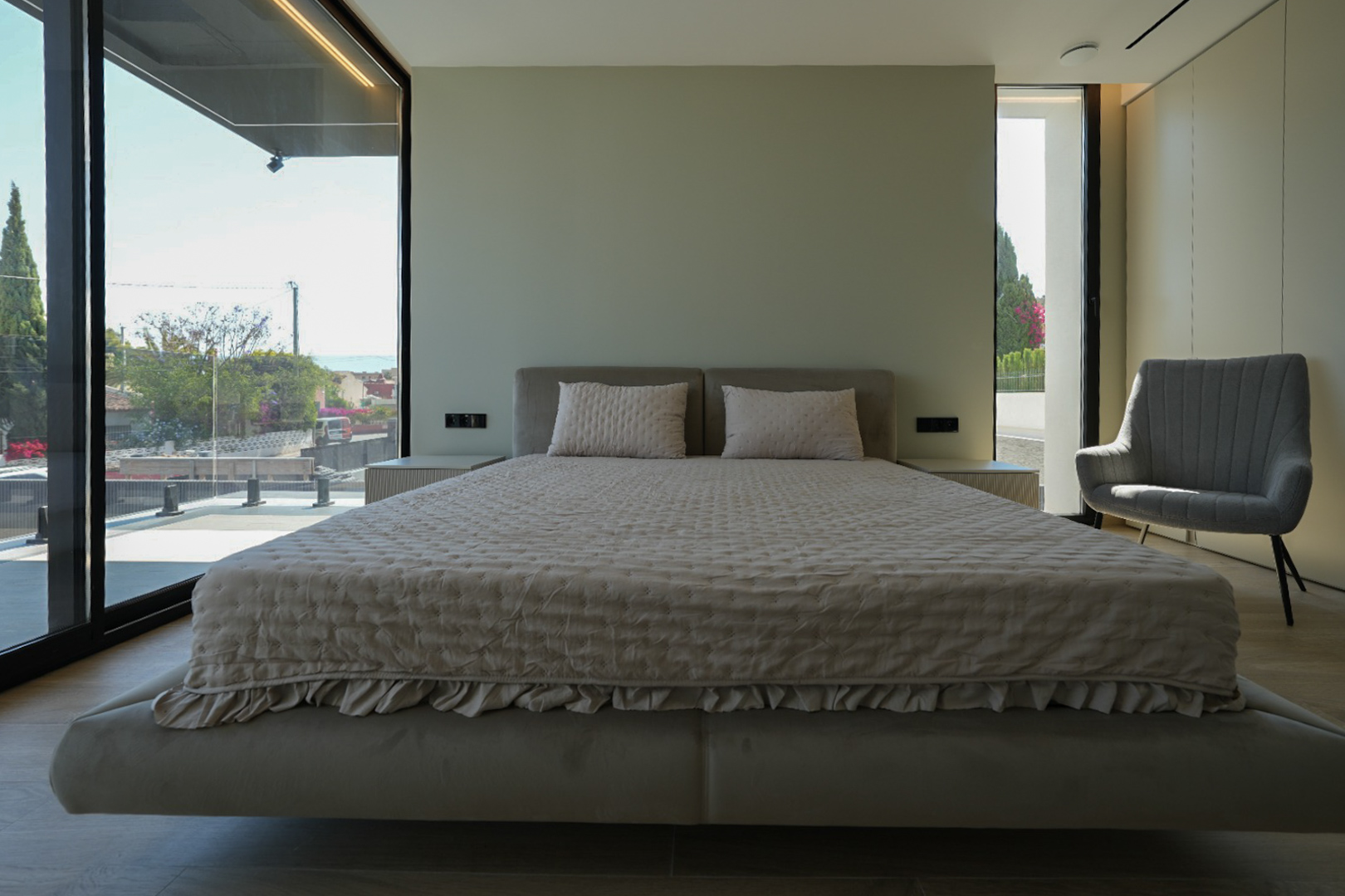 Dormitorio principal con cama flotante, cabecero tapizado, grandes ventanales con vistas al mar y sillón. Mesitas de noche integradas. Dormitorio principal con cama flotante, cabecero tapizado, grandes ventanales con vistas al mar y sillón. Mesitas de noche integradas.