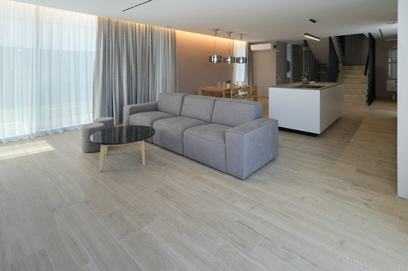 Sala de estar diáfana con sofá modular gris, mesa de centro de mármol negro y suelo de gres porcelánico. Grandes ventanales con cortinas dobles. Sala de estar diáfana con sofá modular gris, mesa de centro de mármol negro y suelo de gres porcelánico. Grandes ventanales con cortinas dobles.