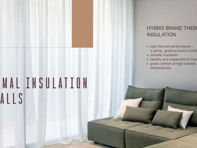 Detalle interior que ilustra la avanzada aislación térmica de las paredes, con un sofá esquinero contemporáneo y cortinas translúcidas.