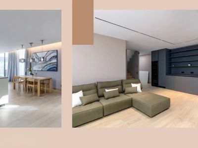Espacio de vida diáfano con isla de cocina moderna, comedor de madera y sofá seccional verde oliva. Almacenamiento integrado gris oscuro y elegante iluminación complementan el diseño.
