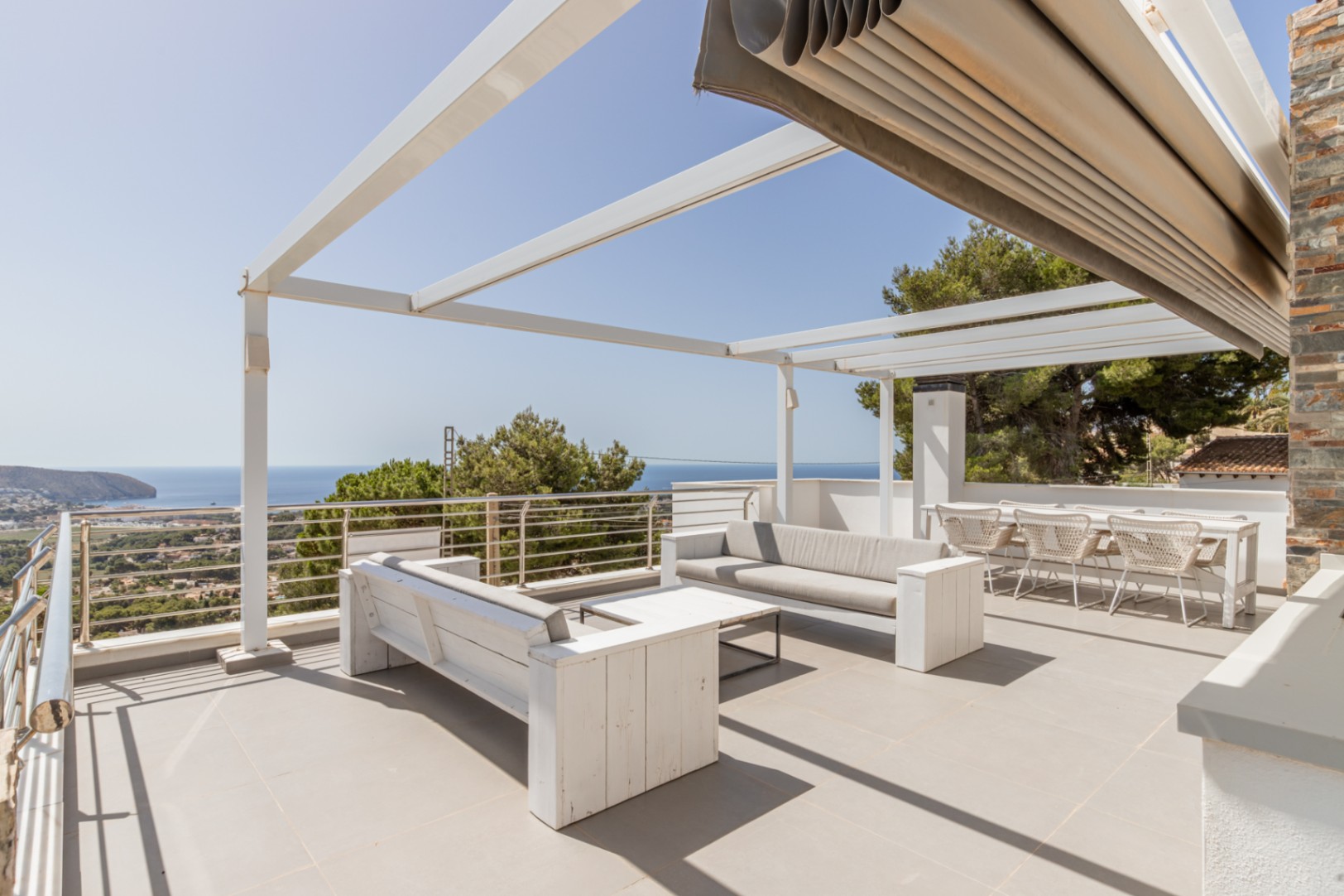 Amplio solárium en la azotea con pérgola blanca, toldo automatizado y zona chill-out con vistas panorámicas al mar. Amplio solárium en la azotea con pérgola blanca, toldo automatizado y zona chill-out con vistas panorámicas al mar.
