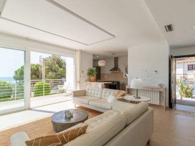 Amplio salón-comedor de planta abierta con cocina integrada, ventanales que acceden a un balcón con vistas al mar y abundante luz natural. Incluye radiador y aire acondicionado por conductos.