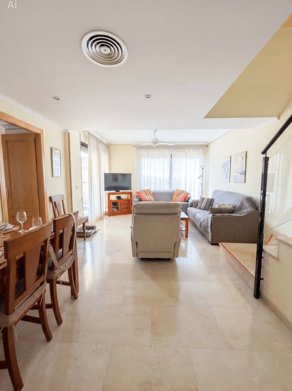 Amplio salón-comedor con suelos de mármol claro, que integra una zona de estar con sofás y un comedor de madera. La estancia recibe luz natural de grandes ventanales y cuenta con aire acondicionado por conductos. Amplio salón-comedor con suelos de mármol claro, que integra una zona de estar con sofás y un comedor de madera. La estancia recibe luz natural de grandes ventanales y cuenta con aire acondicionado por conductos.