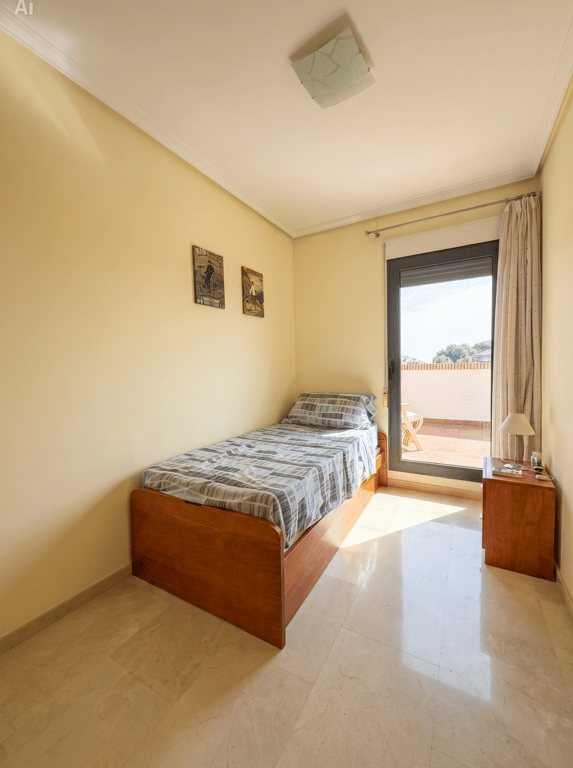 Dormitorio individual con cama de madera, suelo de mármol y acceso directo a una terraza superior, inundado de luz natural. Dormitorio individual con cama de madera, suelo de mármol y acceso directo a una terraza superior, inundado de luz natural.