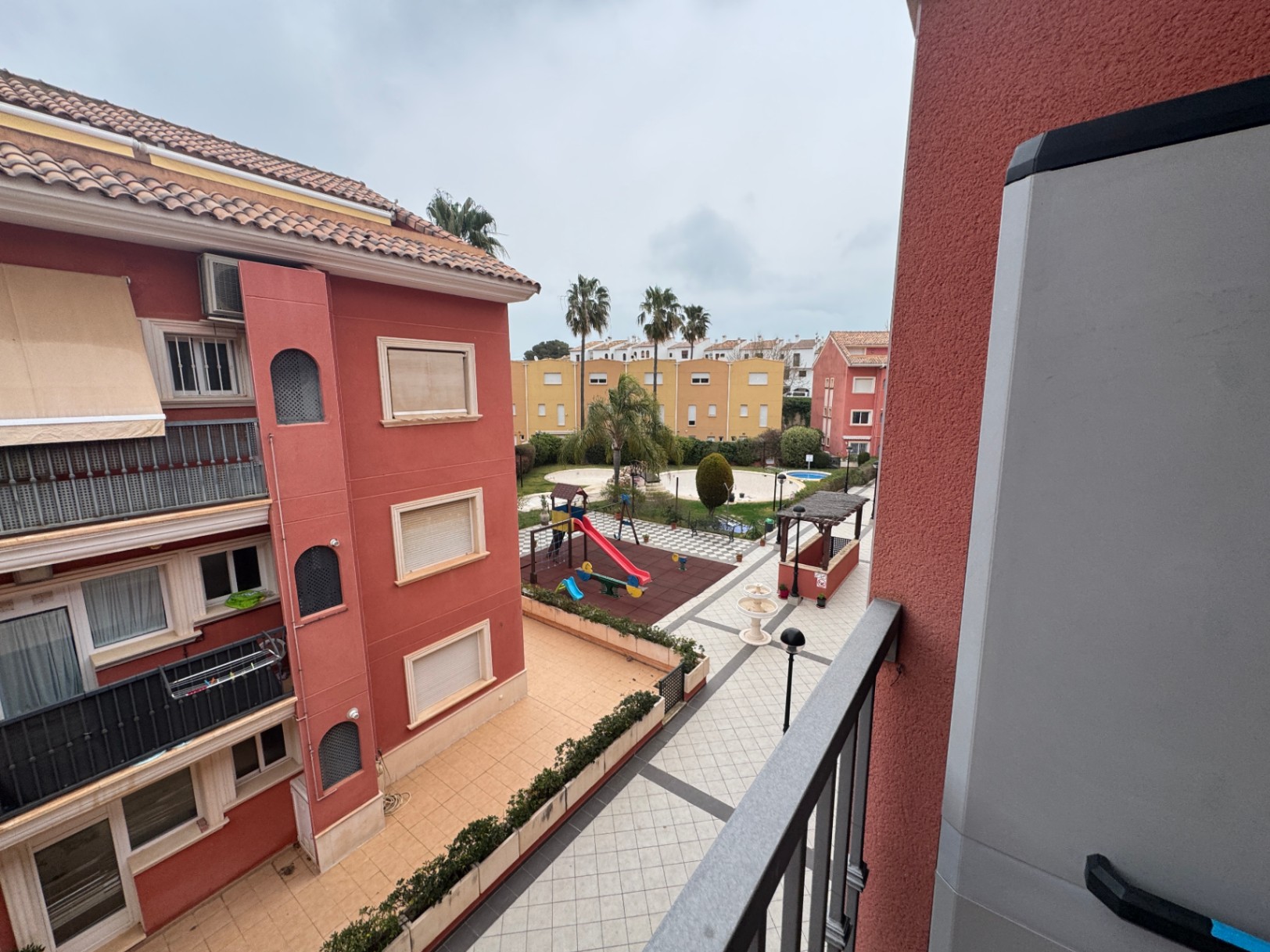 Vista del patio interior con parque infantil desde el balcón.