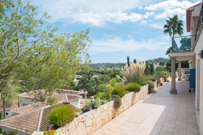 Terraza exterior elevada con suelo de baldosas, muro de piedra con vegetación autóctona y vistas panorámicas al paisaje de Jávea. Terraza exterior elevada con suelo de baldosas, muro de piedra con vegetación autóctona y vistas panorámicas al paisaje de Jávea.