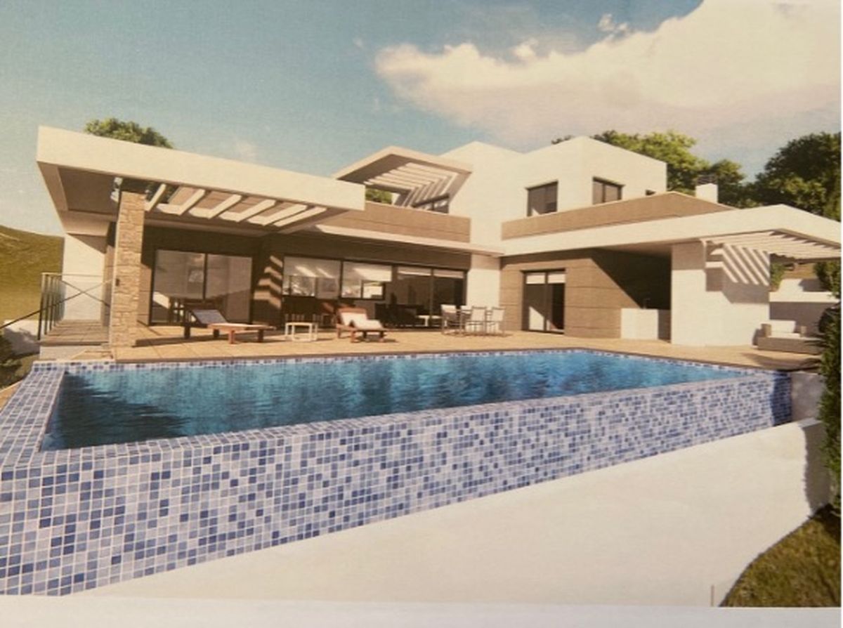 Exterior de villa moderna con piscina de mosaico azul, amplia terraza con tumbonas y arquitectura contemporánea de líneas rectas y detalles en piedra.