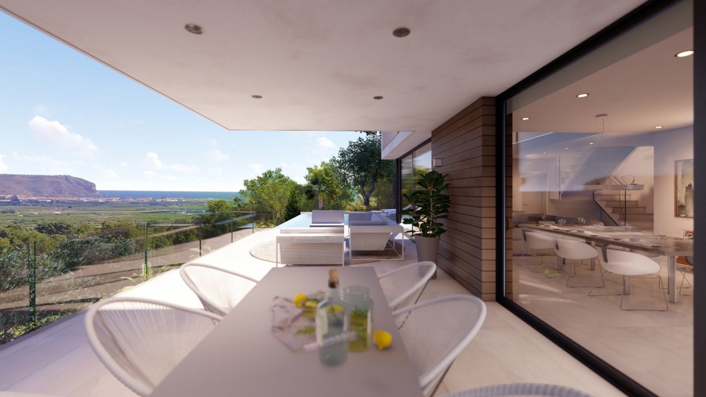 Terraza cubierta con comedor exterior y zona de estar, con vistas panorámicas al valle y acceso directo al salón comedor a través de grandes ventanales.