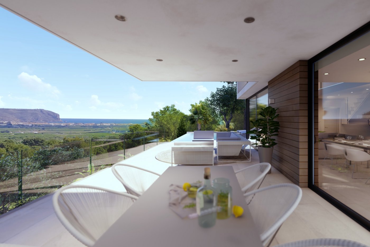 Terraza cubierta con comedor exterior, zona de estar, barandillas de cristal y vistas panorámicas al valle y al mar Mediterráneo.