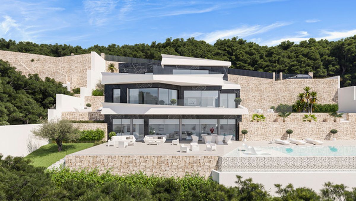 Villa moderna de varios niveles con fachada de piedra oscura y blanca, amplios ventanales y muros de contención de piedra integrados en la ladera boscosa.