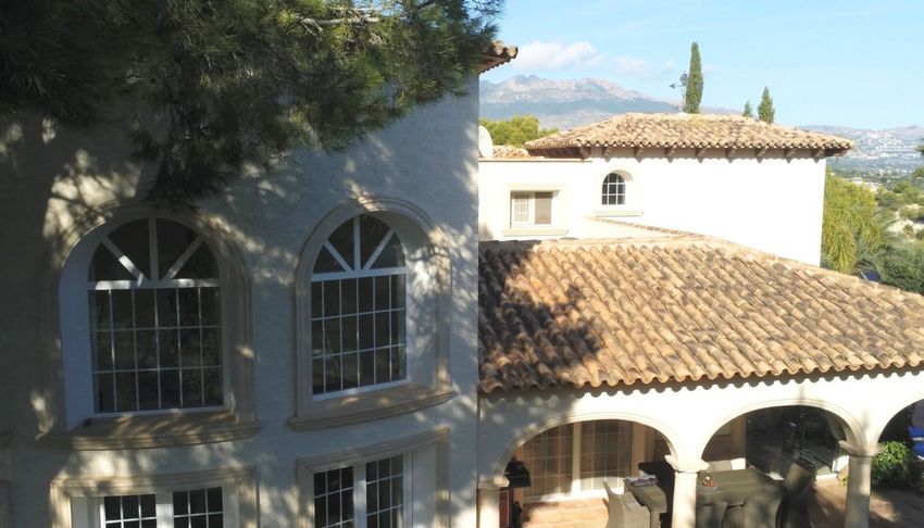La fachada de la villa exhibe elegantes ventanales en arco y tejas de terracota tradicionales. Una terraza exterior sombreada con arcos clásicos ofrece un espacio sereno con vistas a las colinas distantes. La fachada de la villa exhibe elegantes ventanales en arco y tejas de terracota tradicionales. Una terraza exterior sombreada con arcos clásicos ofrece un espacio sereno con vistas a las colinas distantes.