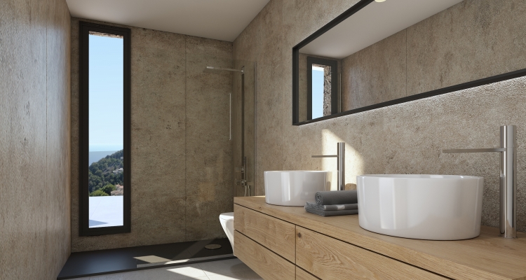 Baño moderno con lavabo doble sobre mueble de madera, paredes de textura pétrea y ducha italiana. El ventanal vertical ofrece vistas al entorno natural.