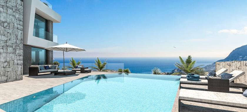 Vista de la piscina infinita con mosaicos azules y tumbonas con vistas al mar. Vista de la piscina infinita con mosaicos azules y tumbonas con vistas al mar.