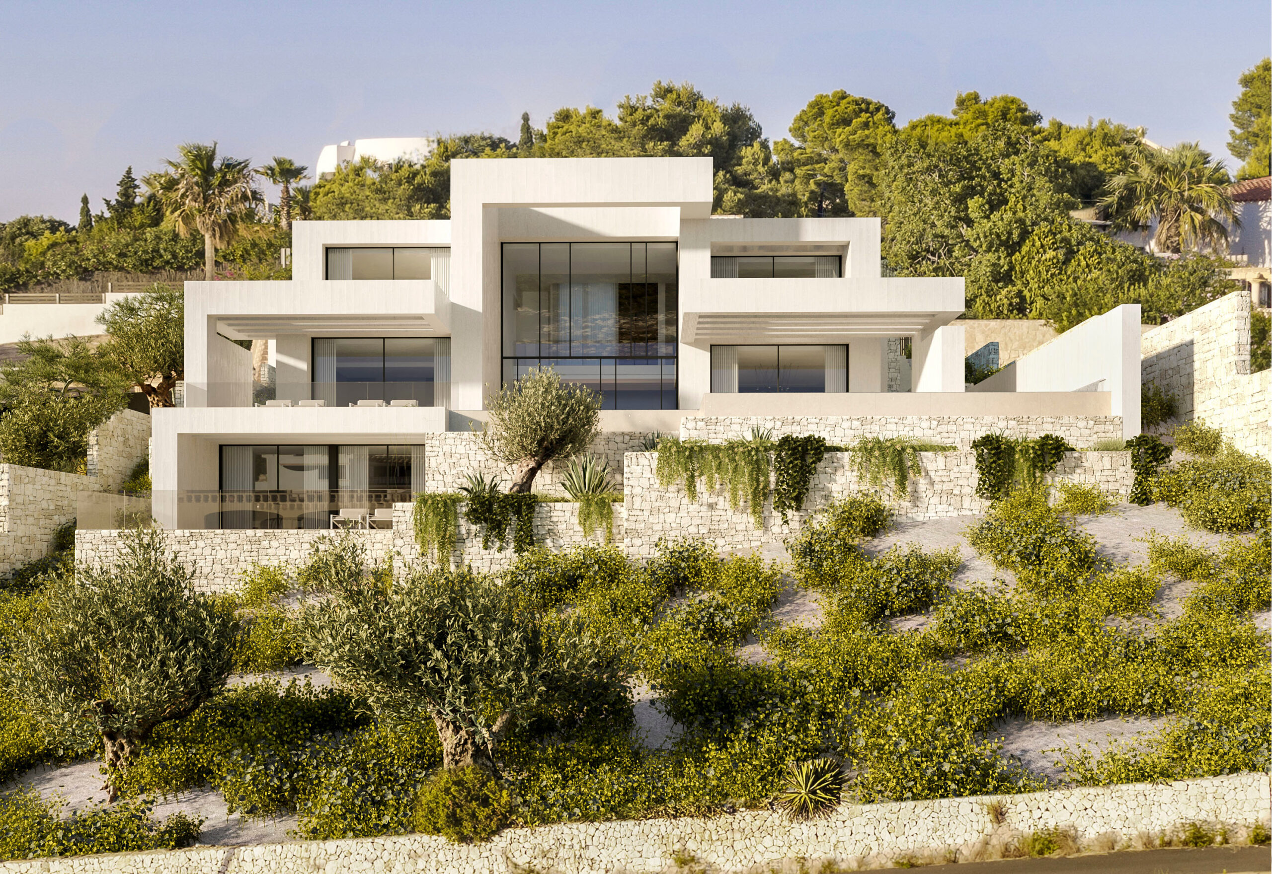 Fachada moderna de color blanco con diseño geométrico y niveles escalonados, integrada en el terreno mediante muros de piedra seca y vegetación mediterránea.