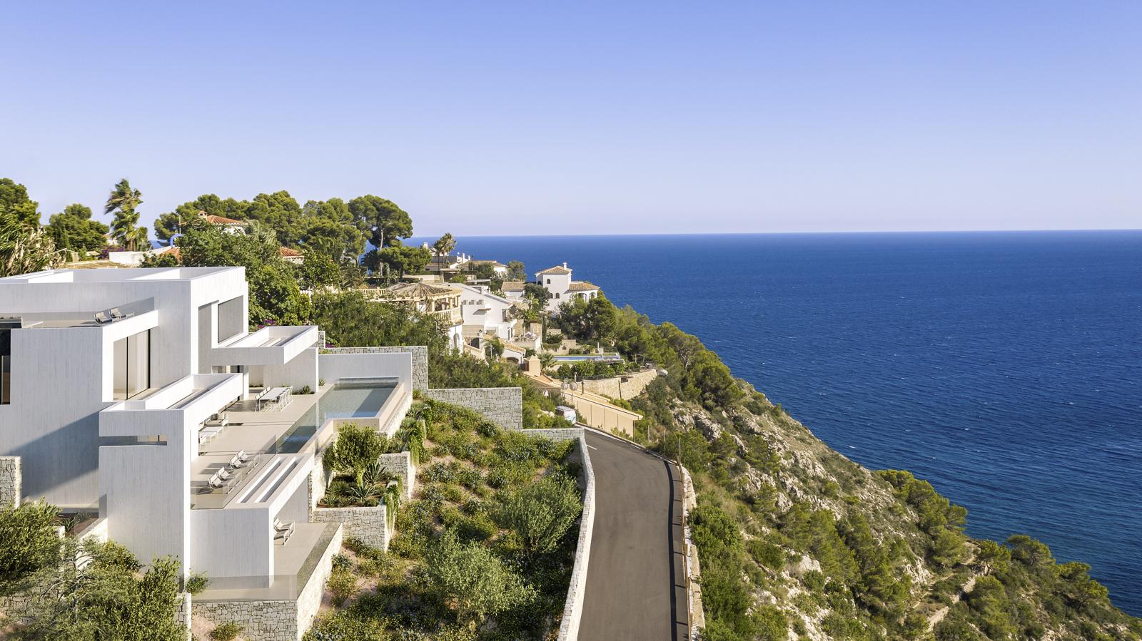 Vista exterior de la villa de diseño moderno con fachada blanca, terrazas escalonadas y piscina infinita frente al mar Mediterráneo en La Granadella.