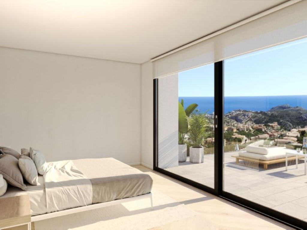 Dormitorio moderno con acceso directo a la terraza mediante ventanales de suelo a techo, ofreciendo vistas panorámicas al mar Mediterráneo.