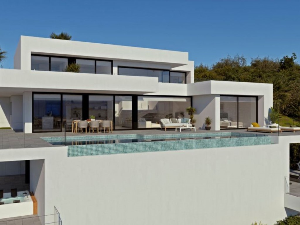 Fachada moderna de líneas blancas con piscina infinita de mosaico turquesa, amplios ventanales y terraza equipada con zonas de comedor y descanso exterior.