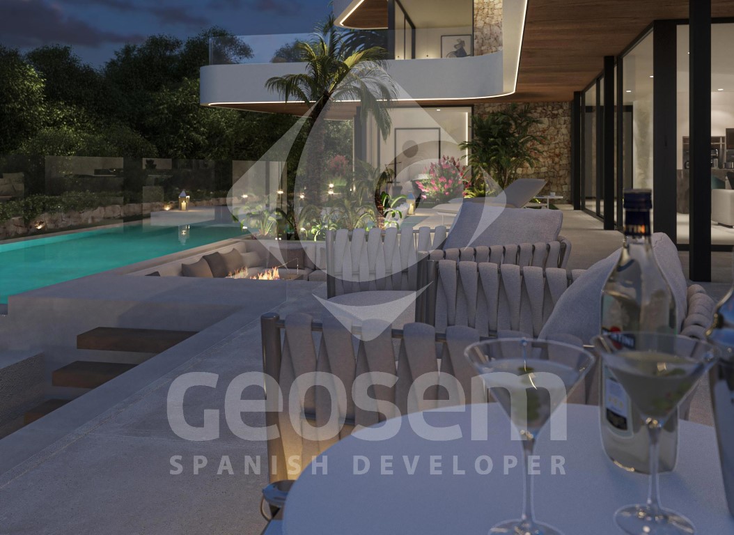 Terraza exterior al atardecer con zona de estar hundida y chimenea, junto a una piscina infinita iluminada y fachada con acabados en piedra y madera.