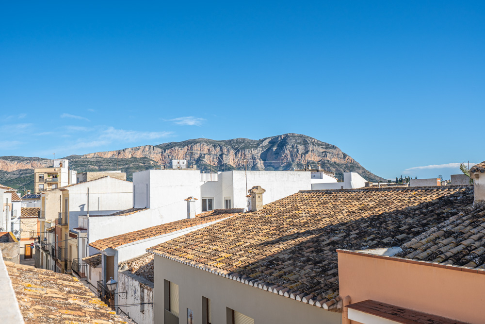 Vistas panorámicas desde la terraza de la azotea hacia el macizo del Montgó, destacando los tejados tradicionales de teja cerámica de Gata de Gorgos.