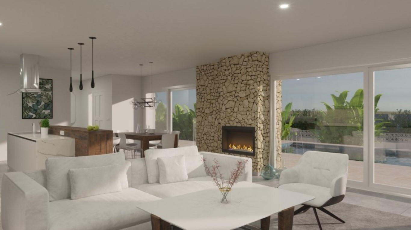 Salón de planta abierta con chimenea encastrada en pared de piedra natural, zona de comedor y cocina moderna con barra de madera, conectado a la terraza con piscina.
