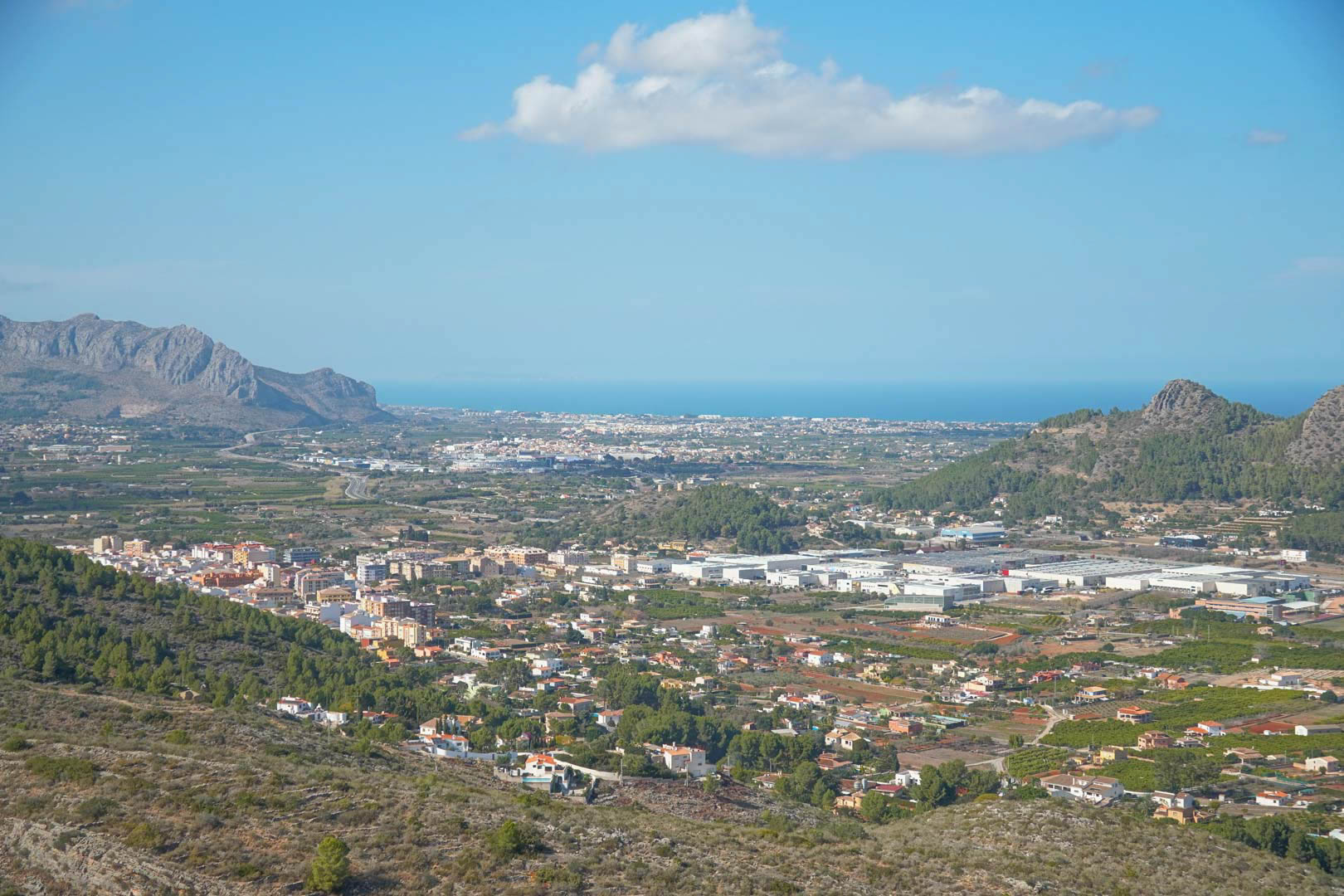 Vistas panorámicas desde la propiedad hacia el valle, las montañas circundantes y el mar Mediterráneo en el horizonte bajo un cielo despejado.