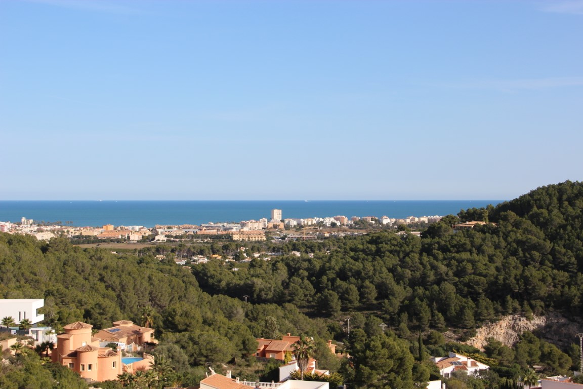 Vistas panorámicas al mar Mediterráneo y al litoral de Jávea desde la elevación de las parcelas, rodeadas de una densa masa forestal de pinos.
