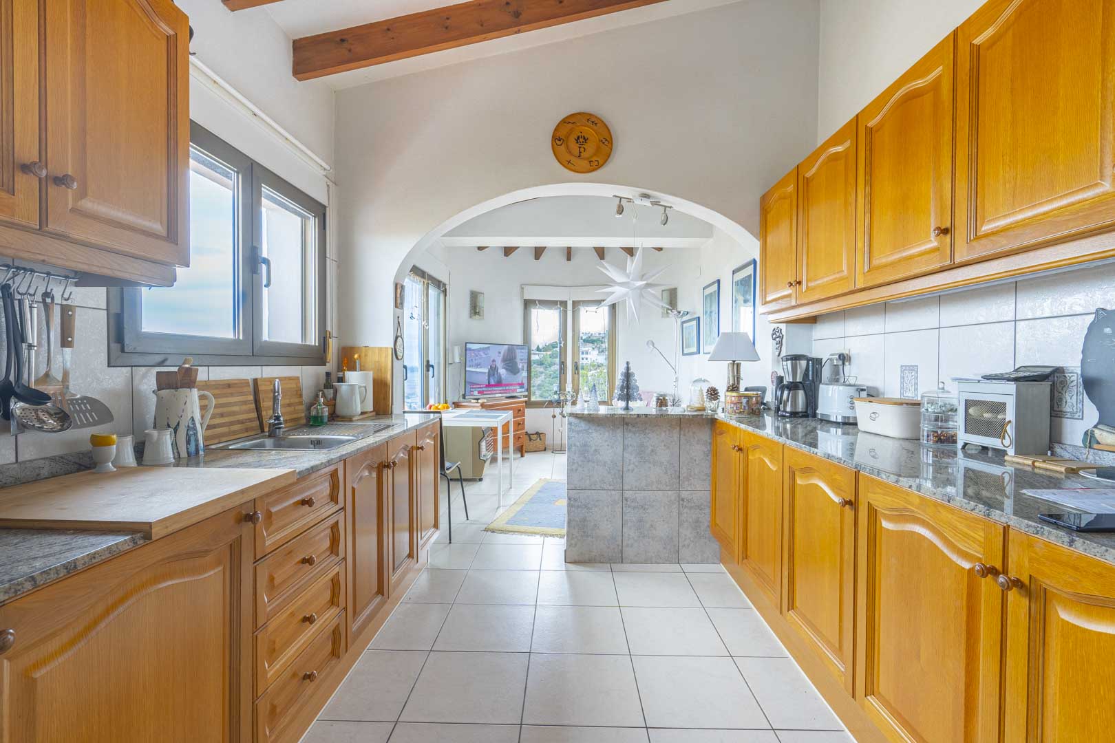 Vista de la cocina americana con encimeras de granito y muebles de madera.